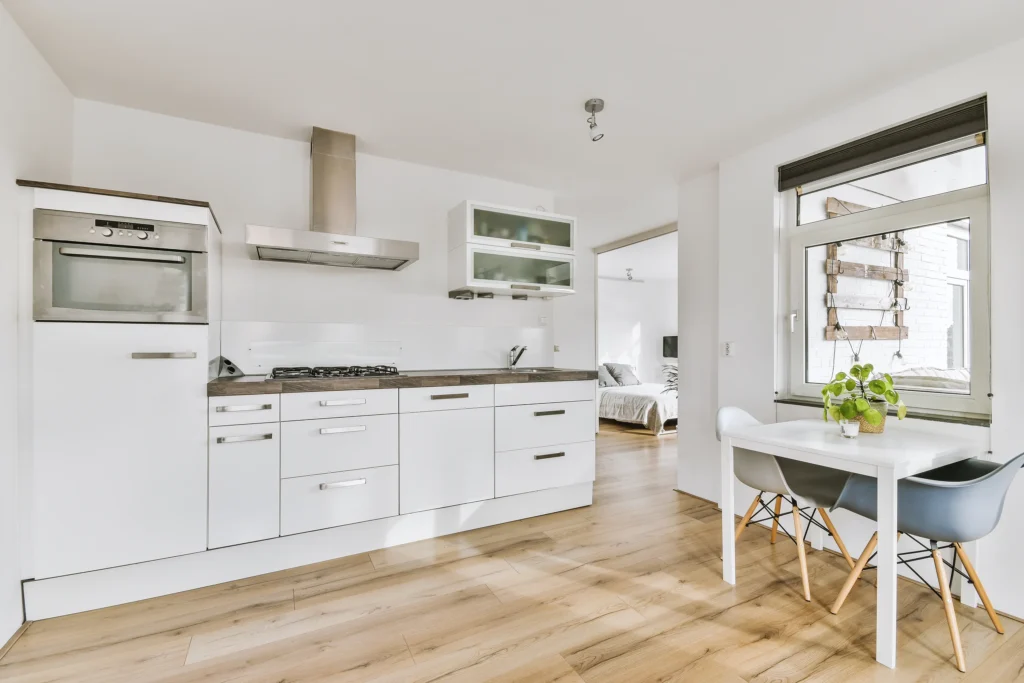 Minimalist kitchen with white cabinetry and natural wood flooring—Truxtun clean-line kitchen style