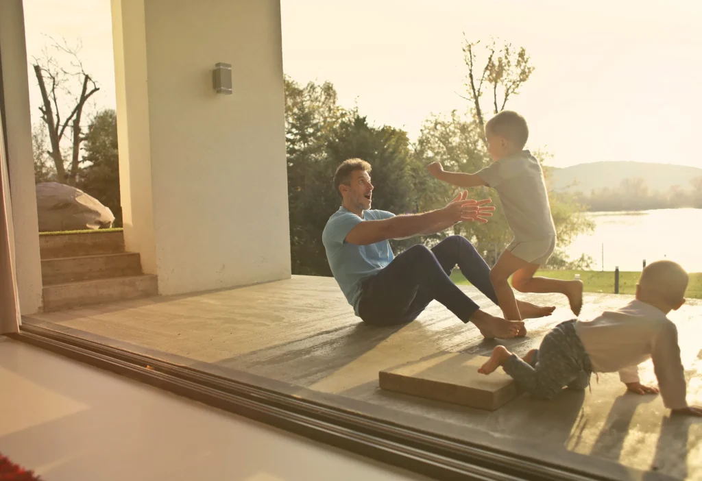 Couple relaxing outside a large sliding door at sunset—Truxtun outdoor-indoor living design