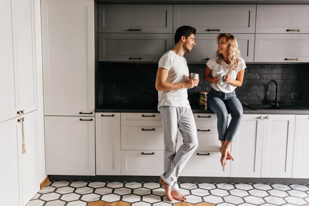 Couple enjoying time in a black and white modern kitchen with patterned flooring—Truxtun interior kitchen design