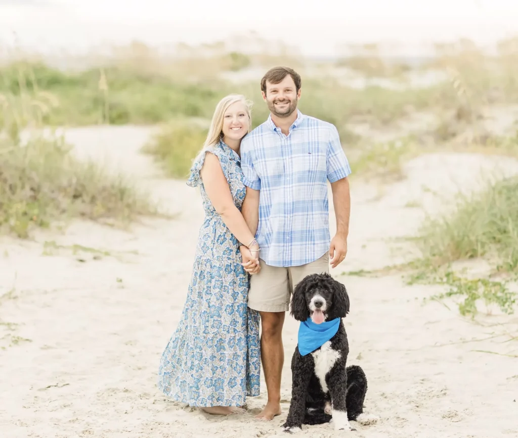 Couple and dog enjoying the beach near coastal dunes—Truxtun clients living the coastal lifestyle in St. Simons Island, GA